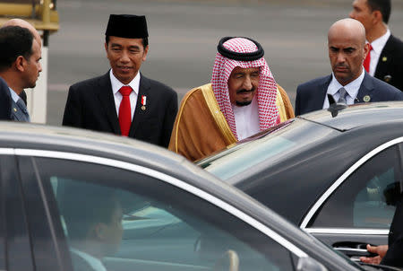 Saudi Arabia's King Salman (C) walks with Indonesia President Joko Widodo as he arrives at Halim Perdanakusuma airport in Jakarta, Indonesia March 1, 2017. REUTERS/Beawiharta