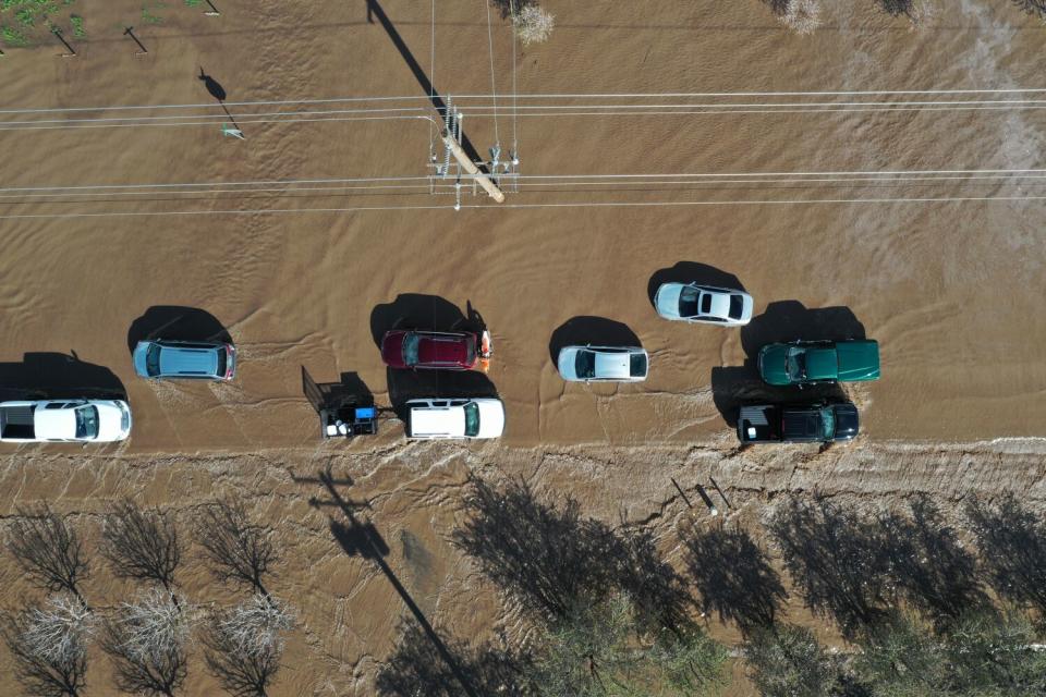 Cars detour on State Route 144 as both sides of Highway 99 are closed due to major flooding in Earlimart in Tulare County.