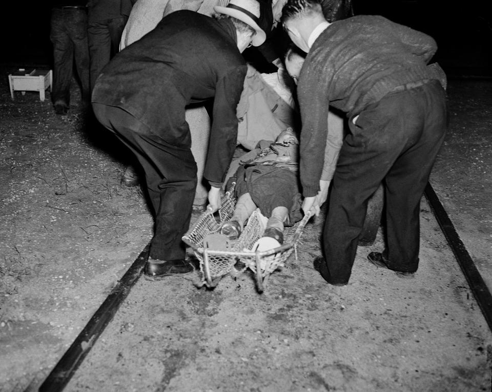 <p>A victim of the Hindenburg disaster is taken away in a stretcher in the aftermath of the airship crash in Lakehurst, N.J., May 6, 1937. The German-built zeppelin burst into flame in mid-air as it was landing after its transatlantic voyage, carrying 97 passengers and crew. Thirty-five people on board and one ground crew member were killed. (AP Photo/Murray Becker) </p>