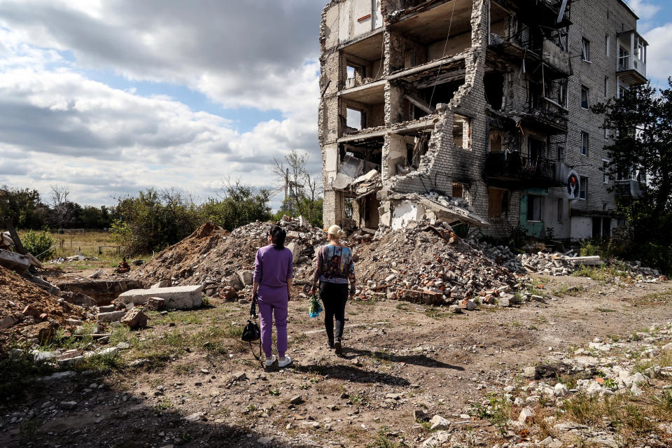 Two women look at an apartment block in Izium, Ukraine, ruined in the shelling of Russian troops on the first anniversary of the liberation of the city from Russian invaders, on Sept. 20, 2023. (Vyacheslav Madiyevskyy / Ukrinform / Future Publishing via Getty Images)