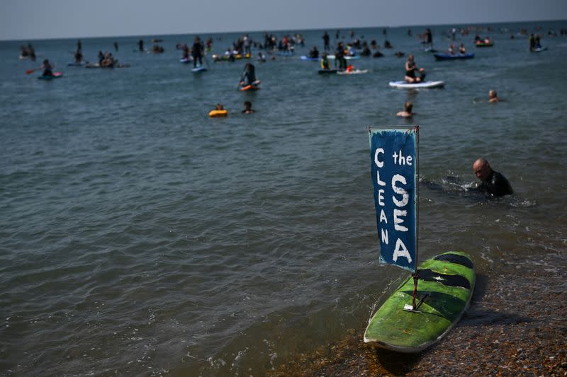 Surfers take part in a mass protest against the continued dumping of untreated sewage by water companies, in Brighton