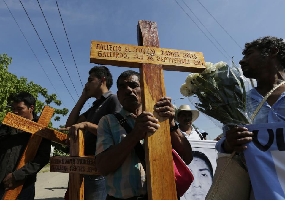 Relatives of missing students of the Ayotzinapa Teacher Training College, Raul Isidro Burgos, participate in a march as they carry crosses with the names of three students who were killed during clashes with police in late September, in Iguala October 27, 2014. Protests spread through the poor, largely rural state in southwest Mexico following the disappearance of 43 students one month ago in the city of Iguala after clashes with police. REUTERS/Henry Romero (MEXICO - Tags: CRIME LAW CIVIL UNREST EDUCATION)