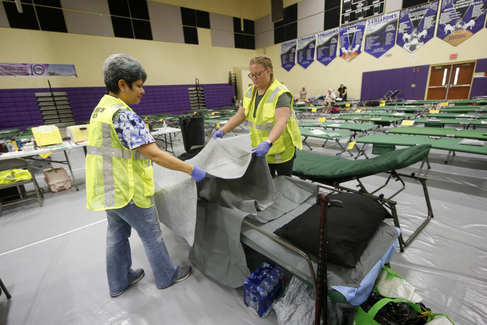 Florida Department of Health staffers set up beds at an evacuation shelter for people with special needs, in preparation for Hurricane Dorian, at Dr. David L. Anderson Middle School in Stuart, Fla., Sunday, Sept. 1, 2019. Some coastal areas are under a mandatory evacuation since the path of the storm is still uncertain. (AP Photo/Gerald Herbert)