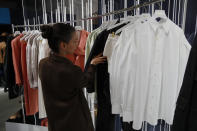 A woman looks at creations by Rihanna as she unveils her first fashion designs for Fenty at a pop-up store in Paris, France, Wednesday, May 22, 2019. Singer Rihanna is the first black woman in history to head up a major Parisian luxury house, and the collection, named after the singer turned designer's last name, comprises of ready-to-wear, footwear, accessories, and eyewear and is available for sale Paris' Le Marais area from Friday and will debut online May 29. (AP Photo/Francois Mori)