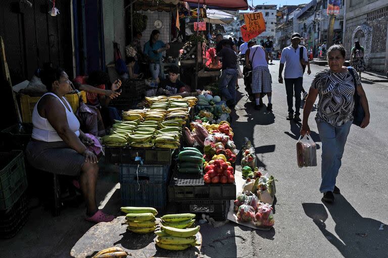 Los residentes caminan por el barrio de Petare mientras compran en un mercado callejero en Caracas el 24 de julio de 2024