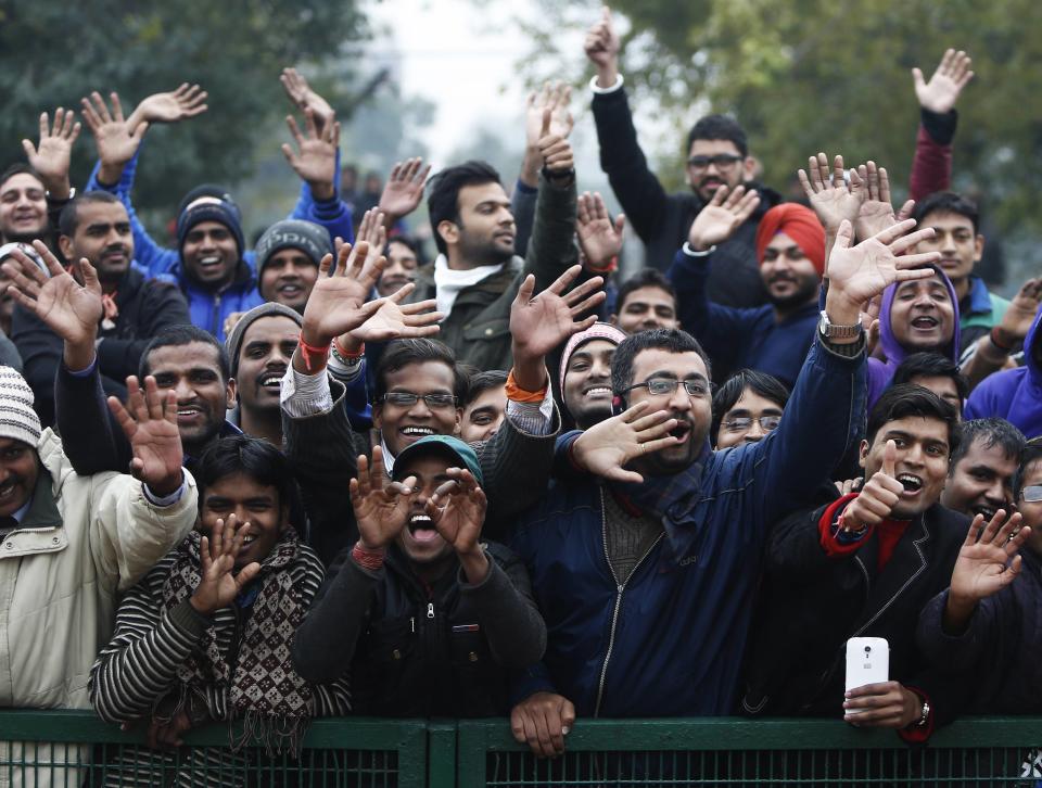 Spectators cheer as a cavalcade carrying U.S. President Obama drives past as he leaves after attending the 66th Republic Day parade in New Delhi