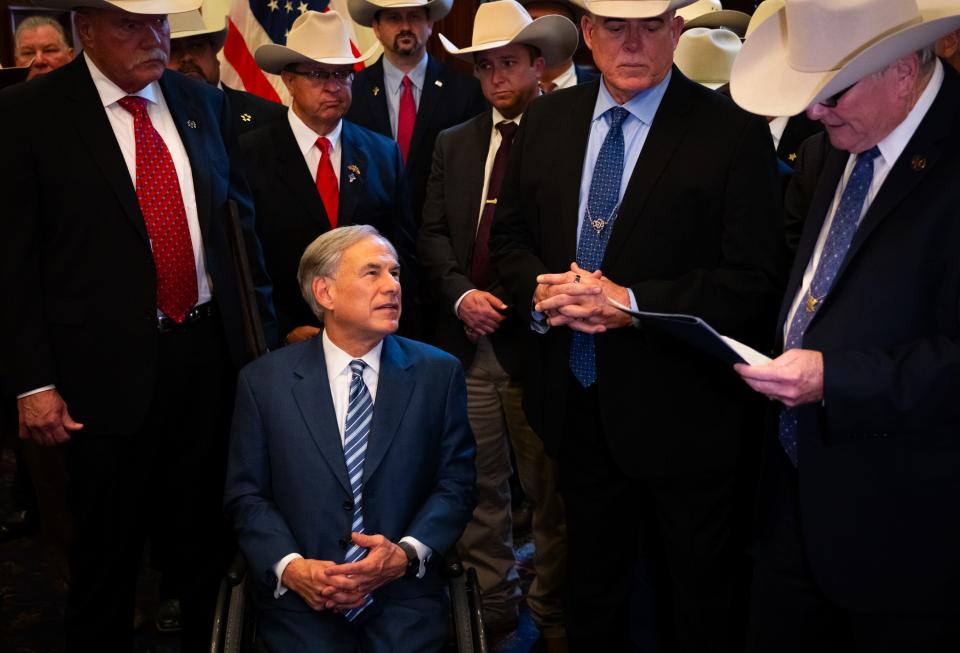 Gov. Greg Abbott listens to Smith County Sheriff and Sheriff's Association of Texas President Larry Smith, left, read a letter from over 100 sheriffs from counties across Texas during a meeting Wednesday between the governor and the sheriffs at the Capitol. Border and immigration issues were topics of discussion at the closed-door meeting.