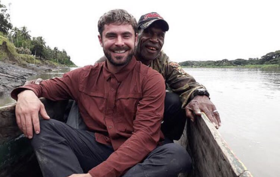 Zac Efron sits in a canoe while filming Killing Zac Efron in Papua New Guinea