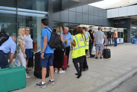 Passengers talk to British Embassy official at Ioannis Kapodistrias Airport after Thomas Cook, the world's oldest travel firm collapsed