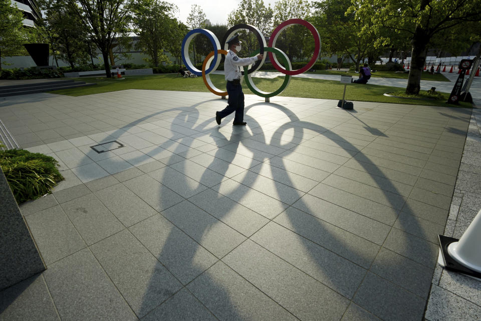 A security guard wearing a protective mask to help curb the spread of the coronavirus walks in front of the Olympic Rings on May 9, 2021, in Tokyo. The Japanese government was quick to respond on Tuesday, May 25, 2021 to U.S. travel warning for Americans against traveling to Japan and denied impact on Olympic participants, as the country determinedly prepare to host the postponed games in two months. (AP Photo/Eugene Hoshiko)