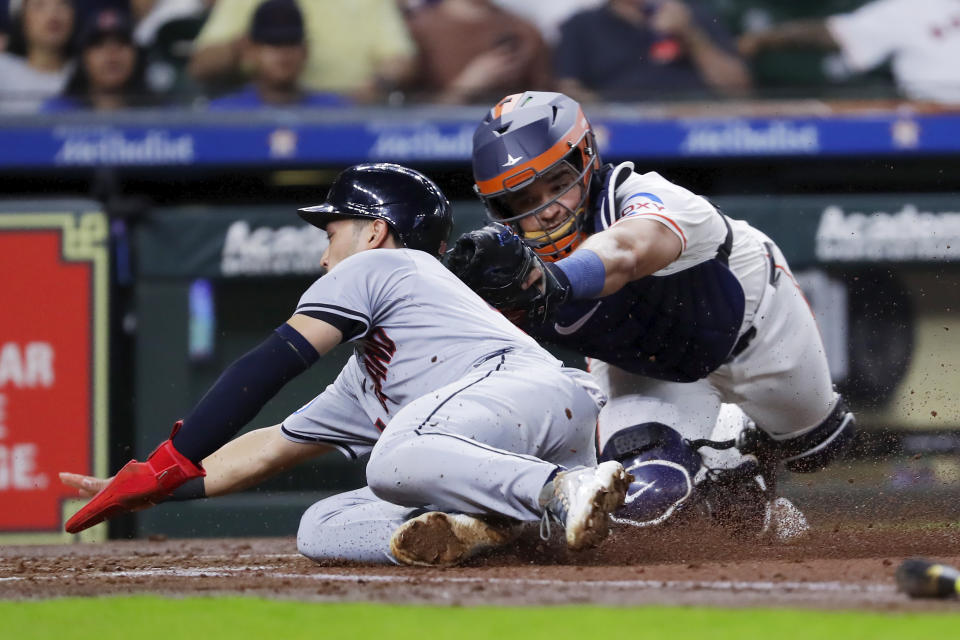 Cleveland Guardians' Steven Kwan, left, beat a tag-attempt by Houston Astros catcher Yainer Diaz, right, to score on the sacrifice fly by Jose Ramirez during the third inning of a baseball game Thursday, May 2, 2024, in Houston. (AP Photo/Michael Wyke)