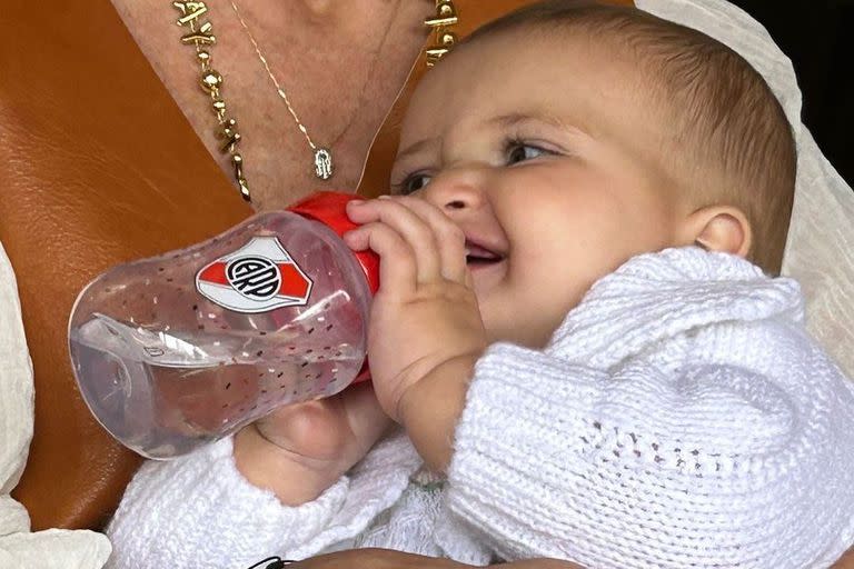 Julia sonriendo con su mamadera de River Plate