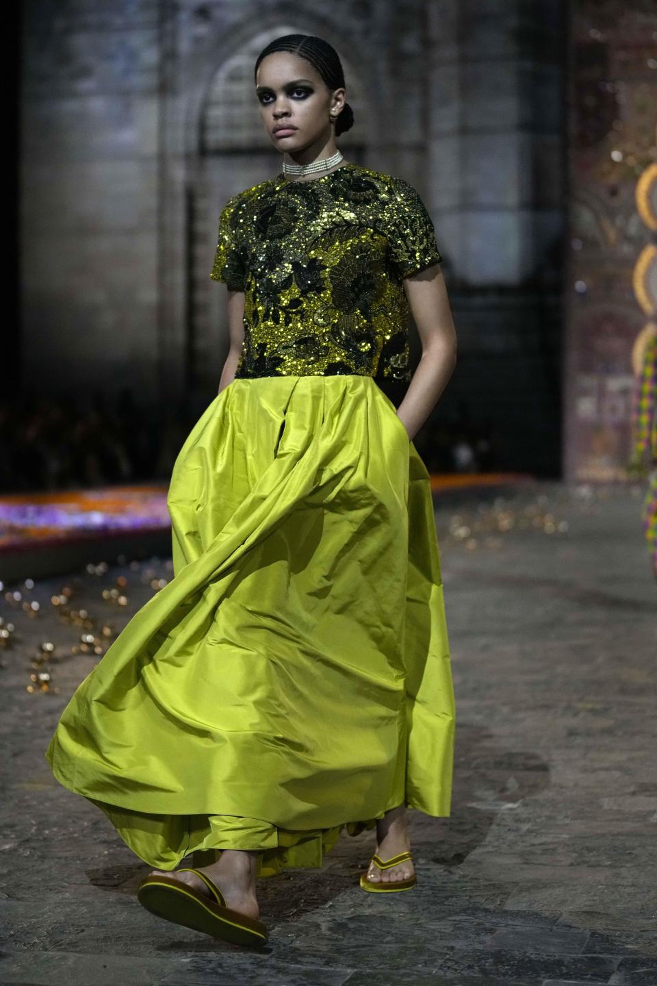A model wears a creation for the Dior Pre-Fall 2023 collection at the Gateway of India landmark monument in Mumbai, India, Thursday, March 30, 2023. (AP Photo/Rafiq Maqbool)