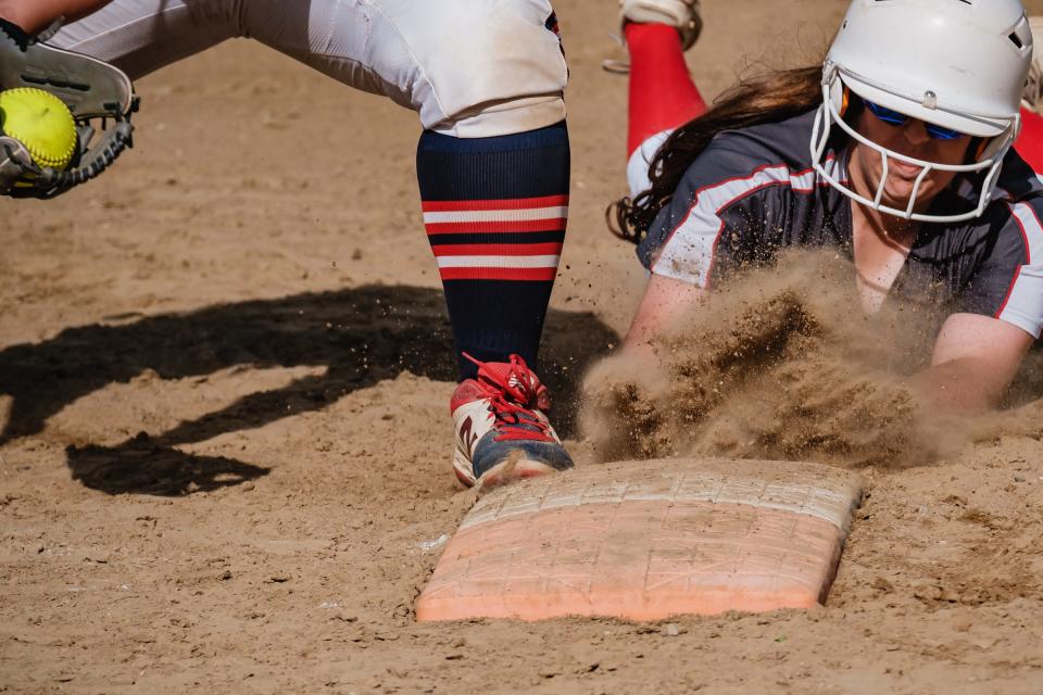 Dover's Avery Contini dives safely back into first during the Division II District softball semifinal against Indian Valley.