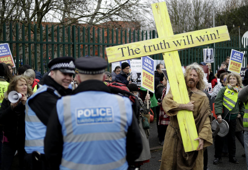 A supporter carries a wooden cross which reads 'The truth will win' as he protest against the extradition of Wikileaks founder Julian Assange outside Belmarsh Magistrates Court in London, Monday, Feb. 24, 2020. The U.S. government and WikiLeaks founder Julian Assange will face off Monday in a high-security London courthouse, a decade after WikiLeaks infuriated American officials by publishing a trove of classified military documents. (AP Photo/Matt Dunham)
