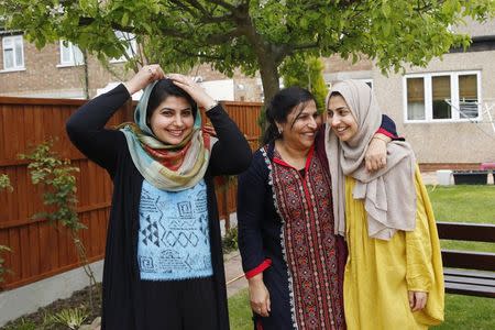 Sundas, her mother Naheed (C), and sister Shanza (R), pose for a photograph after an interview with Reuters, at home in Walthamstow, east London November 16, 2013. REUTERS/Olivia Harris