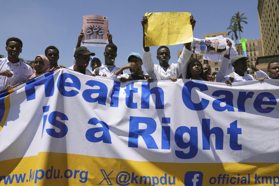 Doctors and other medical staff take part in a protest, in downtown Nairobi, Kenya, Friday, March 22, 2024. Hundreds of Kenyan doctors have protested in the streets demanding better pay and working conditions in an ongoing nationwide strike that has entered its second week. The doctors carried placards and chanted against the Kenyan government on Friday, saying it had failed to implement a raft of promises, including a collective bargaining agreement signed in 2017 after a 100-day strike during which people died from lack of care. (AP Photo/Brian Inganga)