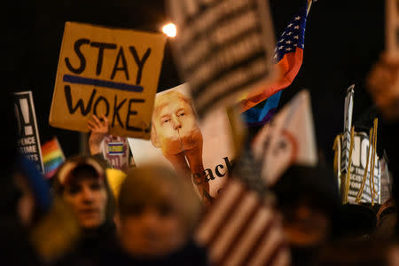 People hold signs at a protest against U.S. President-elect Donald Trump near Trump Tower in New York City, U.S. January 19, 2017. REUTERS/Stephanie Keith
