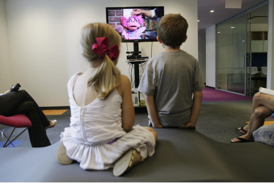 In this Sept. 5, 2012, photo, from left, Zoe Shyba, 3, and Aidan Lain, 7, play "Kinect Sesame Street TV" at the Sesame Street Workshop in New York. "Kinect Sesame Street TV", launching Tuesday, Sept. 18, 2012, uses Kinect, a motion and voice-sensing controller created by Microsoft, to give Elmo, Big Bird and the rest of the Sesame Street crew a chance to have a real two-way conversation with their pint-sized audience. The effort represents the next step in the evolution of television, adding an interactive element to what's still largely a passive, lean-back experience. (AP Photo/Mark Lennihan)