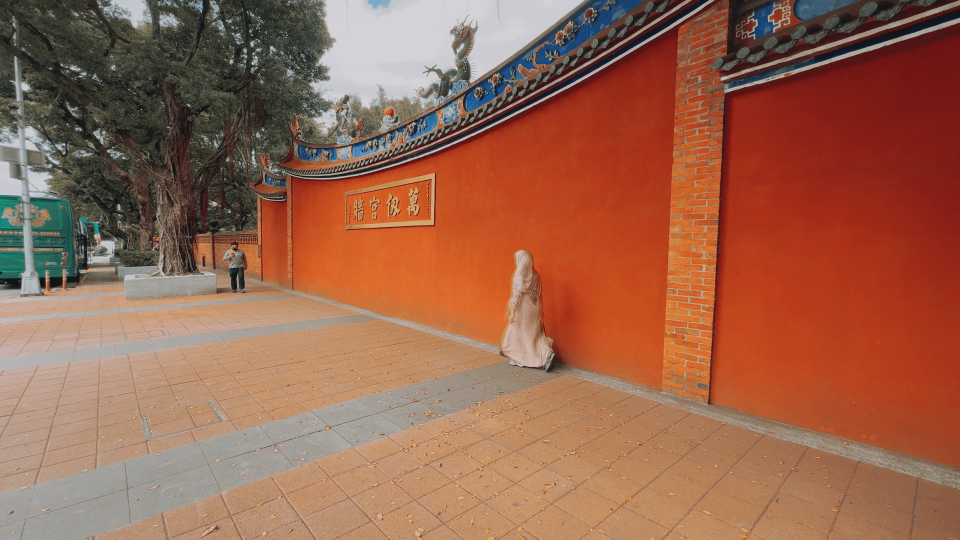 大龍峒保安宮外圍徒步區磚紅色圍牆格外醒目，與徒步區相輝映，極具歷史感。（鏡新聞）
