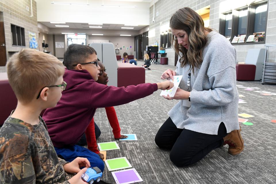 First graders DJ Lap, Ivan Pittman and Callen Redmond talk about a coding puzzle with their teacher, Danielle Martin, on Thursday, December 8, 2022, at Adventure Elementary in Harrisburg.