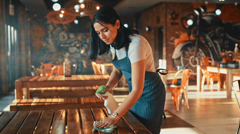 woman cleaning restaurant table