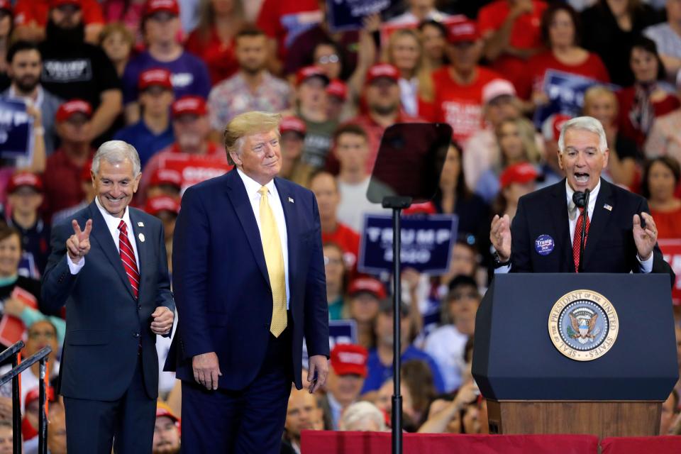 President Donald Trump introduces Louisiana Republican gubernatorial candidates Eddie Rispone, left, and Ralph Abraham, during a campaign rally in Lake Charles, La. The two are running against incumbent Democrat Gov. John Bel Edwards.