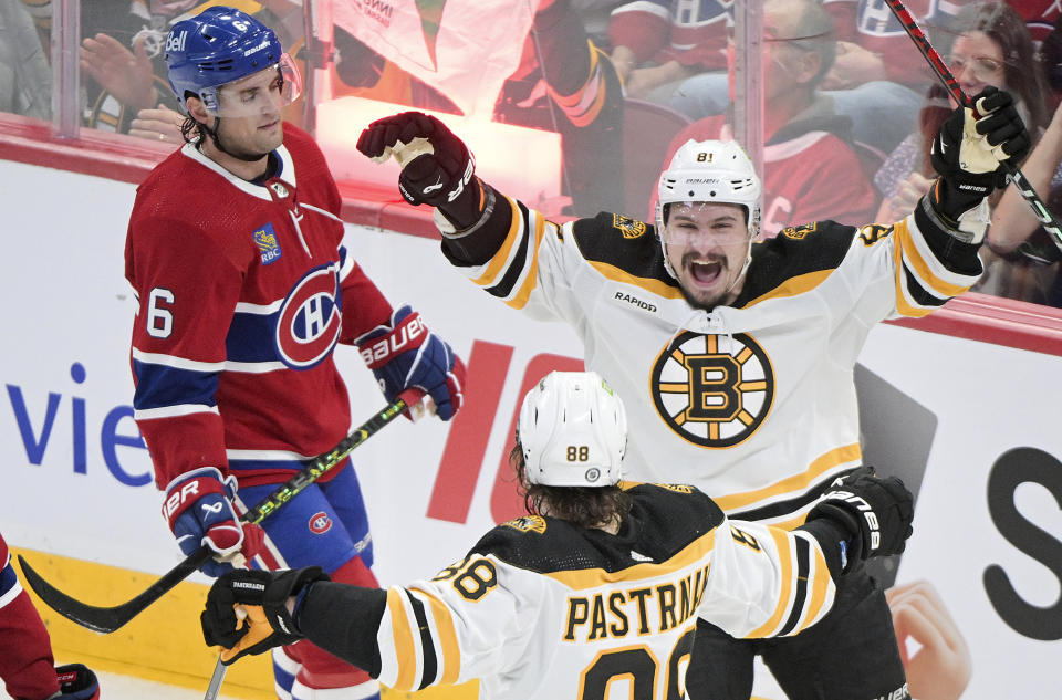 Boston Bruins' David Pastrnak (88) celebrates with Dmitry Orlov (81) after scoring against the Montreal Canadiens during the third period of an NHL hockey game Thursday, April 13, 2023, in Montreal. (Graham Hughes/The Canadian Press via AP)