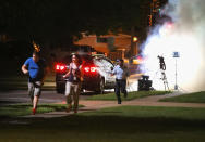 <p>An Al Jazeera television crew, covering demonstrators protesting the shooting death of teenager Michael Brown, scramble for cover as police fire tear gas into their reporting position on August 13, 2014 in Ferguson, Missouri. Brown was shot and killed by a Ferguson police officer on Saturday. Ferguson, a St. Louis suburb, is experiencing its fourth day of violent protests since the killing. (Scott Olson/Getty Images) </p>