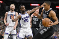 Sacramento Kings' Harrison Barnes (40) tangles with San Antonio Spurs' Keldon Johnson, right, during the second half of an NBA basketball game, Sunday, Jan. 15, 2023, in San Antonio. (AP Photo/Darren Abate)