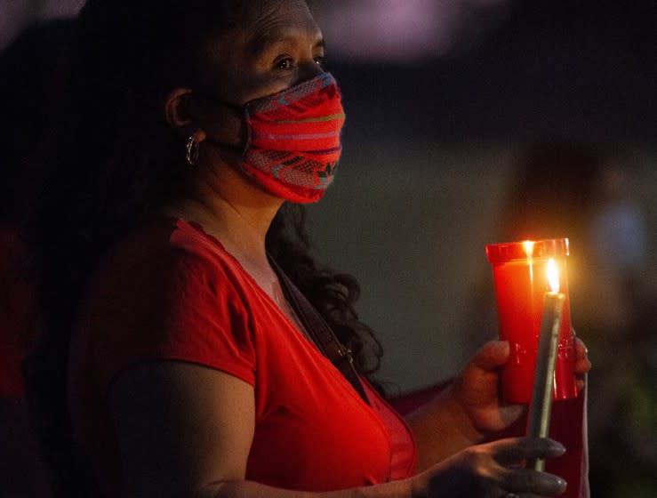 People gather for a community candlelight vigil at the Max Foster Sports Complex in Livingston, Calif.