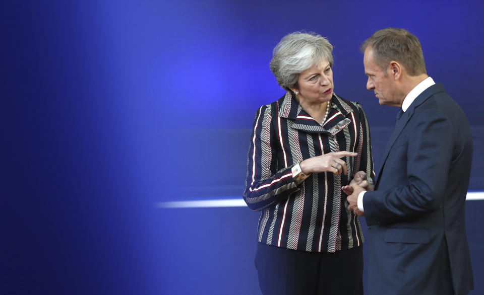 British Prime Minister Theresa May, left, speaks with European Council President Donald Tusk after a group photo during an EU-ASEM summit in Brussels, Friday, Oct. 19, 2018. EU leaders met with their Asian counterparts Friday to discuss trade, among other issues. (AP Photo/Francisco Seco)