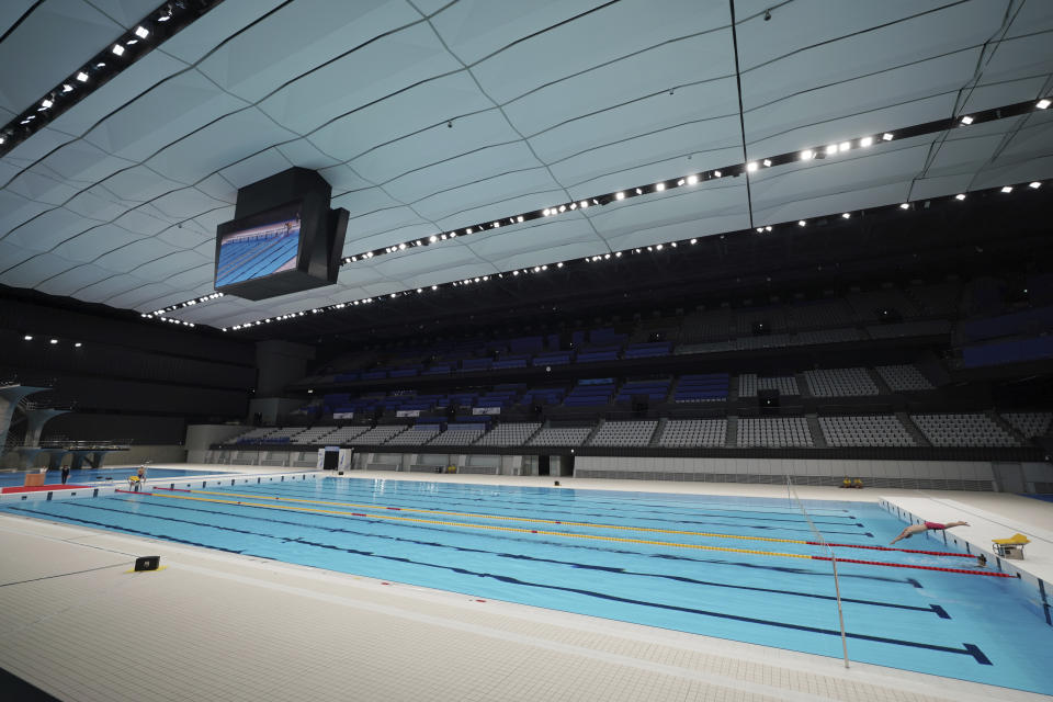 A swimmer demonstrates during a grand opening ceremony of Tokyo Aquatics Center Saturday, Oct. 24, 2020, in Tokyo. The Tokyo 2020 organizing committee held the grand opening ceremony Saturday at the aquatics center, planned to host Olympic artistic swimming, diving and swimming and Paralympics swimming events in 2021. (AP Photo/Eugene Hoshiko)