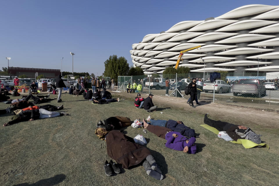 Football fans rest outside the Basra International Stadium in Basra, Iraq, Thursday, Jan 19, 2023. A stampede outside the stadium has killed and injured a number of people. (AP Photo/Anmar Khalil)