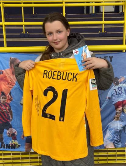 Leah Walton holding a shirt signed by Lioness Ellie Roebuck (Craig Walton/PA)