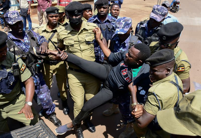 Ugandan riot police officers detain an activist during a march in support of the European Parliament resolution to stop the construction of the East African Crude Oil Pipeline in Kampala