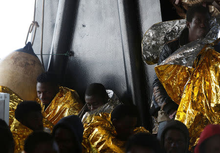 Migrants rest on the deck of Malta-based NGO Migrant Offshore Aid Station (MOAS) ship Phoenix after being rescued from a rubber dinghy in central Mediterranean on international waters some 15 nautical miles off the coast of Zawiya in Libya, April 14, 2017. REUTERS/Darrin Zammit Lupi