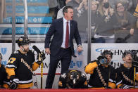 Pittsburgh Penguins head coach Mike Sullivan stands on his bench to get the referee's attention during the overtime period of an NHL hockey game against the Detroit Red Wings in Pittsburgh, Friday, Jan. 28, 2022. (AP Photo/Gene J. Puskar)