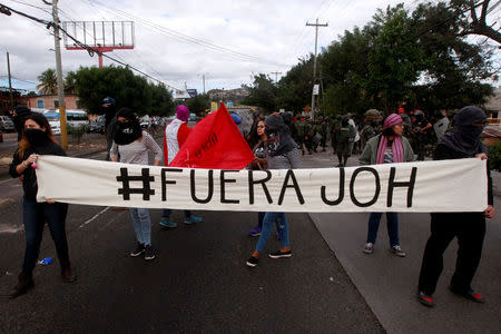 Demonstrators hold a banner during a protest against the re-election of Honduras' President Juan Orlando Hernandez in Tegucigalpa, Honduras January 20, 2018. Banner reads "#Out Juan Orlando Hernandez". REUTERS/Jorge Cabrera
