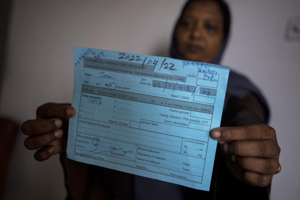 Jesmi Fatima shows a prescription given by doctors to undergo pathology tests that were already delayed due to lack of supplies in Colombo, Sri Lanka, June 3, 2022. Doctors in Sri Lanka are urging their patients not to fall ill or get into accidents as the country's economic crisis leaves its trusted health system without medicines and other vital supplies. Sri Lanka has run short of money to pay for basic imports like fuel and food, and medicine has also run scarce. (AP Photo/Eranga Jayawardena)