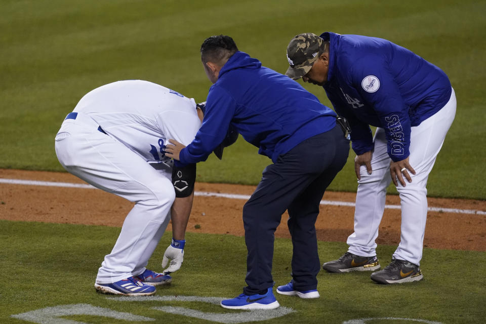 Los Angeles Dodgers' Corey Seager, left, reacts after being hit by a pitch from Miami Marlins relief pitcher Ross Detwiler (54) during the fifth inning a baseball game Saturday, May 15, 2021, in Los Angeles. (AP Photo/Ashley Landis)