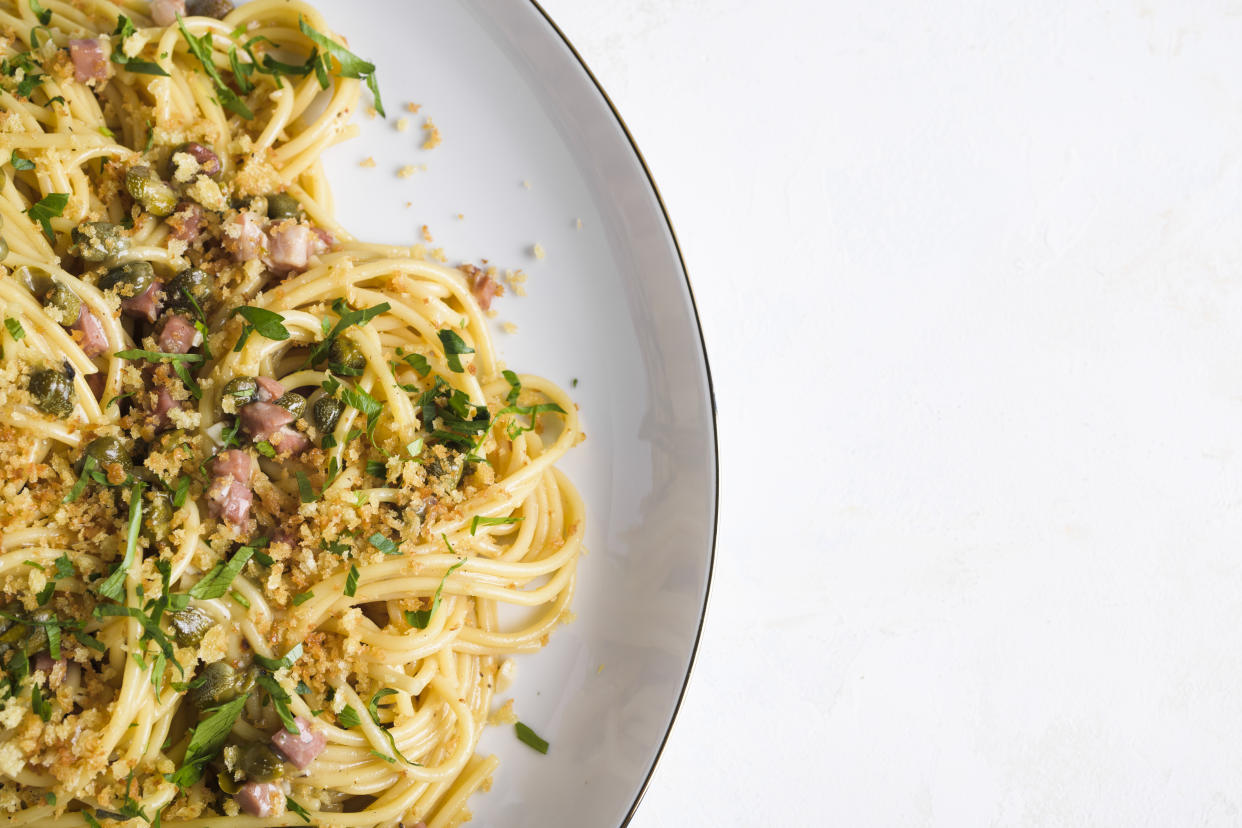 This image released by Milk Street shows a recipe for Lemon Caper Spaghetti with Pancetta and Toasted Breadcrumbs. (Milk Street via AP)