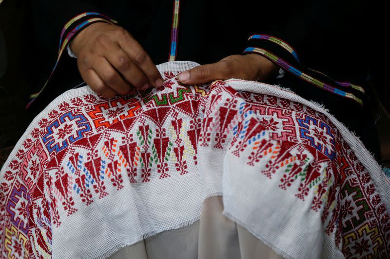 Um Zeid, 47 year-old Palestinian refugee woman living in Jordan embroiders a traditional Palestinian dress for customers at Al-Baqaa Palestinian refugee camp, near Amman