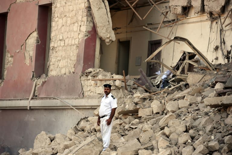 An Egyptian policeman stands in the rubble at the site of a powerful bomb explosion that ripped through the Italian consulate, killing one person, on July 11, 2015, in Cairo