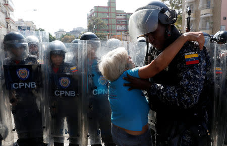 A woman is helped by a police officer after she fainted during clashes with police in a rally against Venezuelan President Nicolas Maduro's government in Caracas, Venezuela March 9, 2019. REUTERS/Carlos Garcia Rawlins