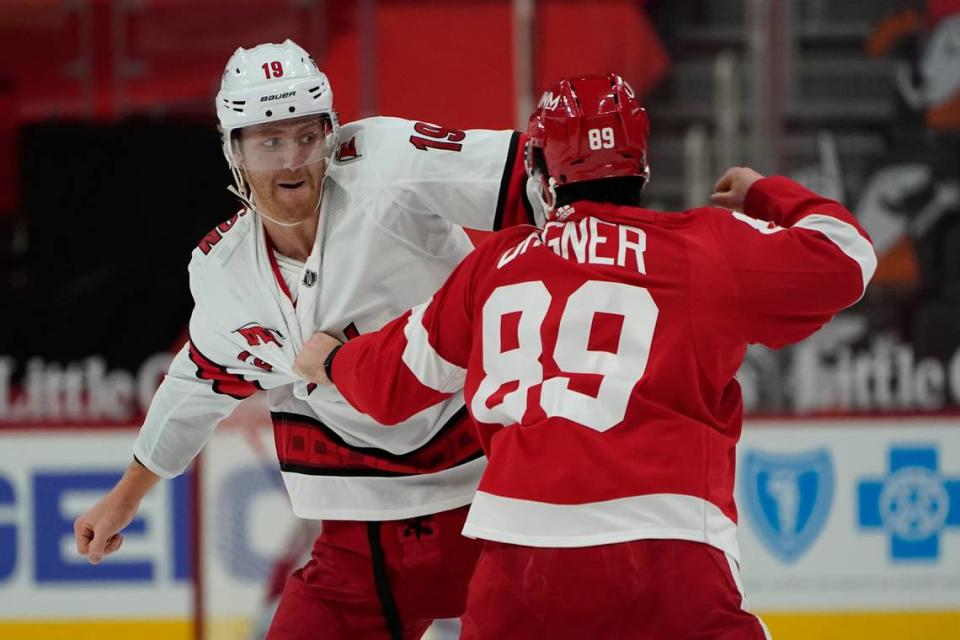 Carolina Hurricanes defenseman Dougie Hamilton (19) and Detroit Red Wings center Sam Gagner (89) fight in the second period of an NHL hockey game Thursday, Jan. 14, 2021, in Detroit. (AP Photo/Paul Sancya)