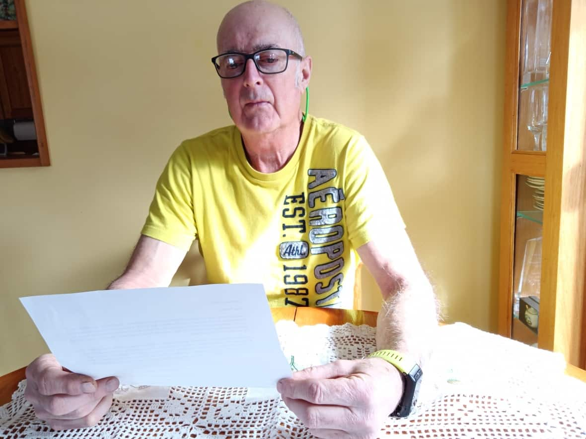 Ron Flynn of Alberton reads the letter he received informing him that his family physician, Dr. Hal McRae, would be closing his Summerside practice on April 20. (Susan Flynn - image credit)