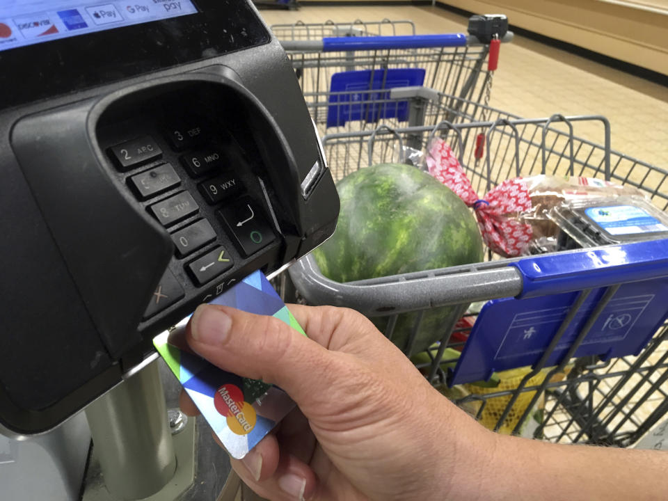 FILE- In this July 17, 2018 photo, a customer buys groceries with a credit card in Salem, N.H. (AP Photo/Elise Amendola, File)
