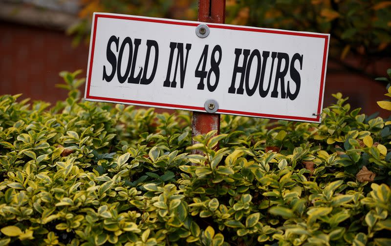 A sign is pinned beneath an estate agent’s board outside a housing development in Manchester