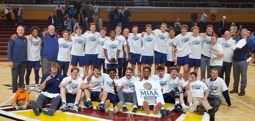 The Hope College men's basketball team celebrates winning the MIAA title on Saturday at Calvin.